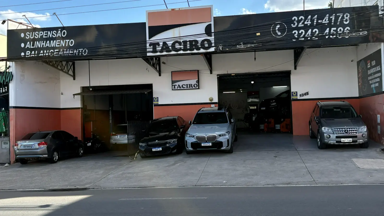 Fachada da Taciro Auto Center na R. Carolina Florence, 1345, com as duas oficinas abertas e carros estacionados na calçada