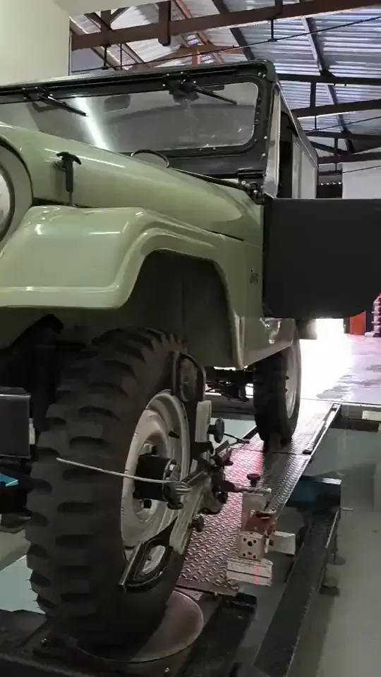 Mecânico da Taciro ajustando a geometria das rodas de um Jeep antigo sobre o alinhador Hunter